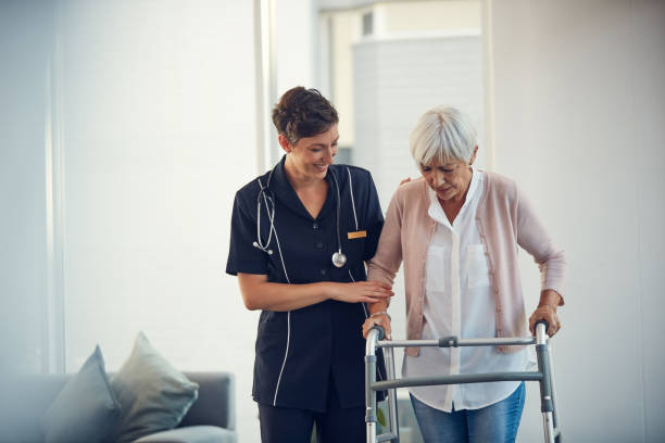 7 Cropped shot of a young nurse assisting a senior woman walk using a walker in a nursing home