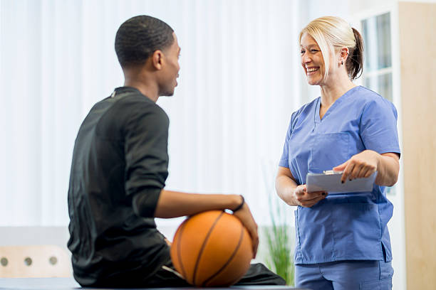 M1 A male teenage basketball player is at the doctors office to have some work done on his injury. He is telling they nurse where he was hurt.